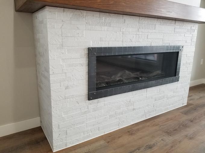 Stacked-stone linear fireplace with a timber mantel