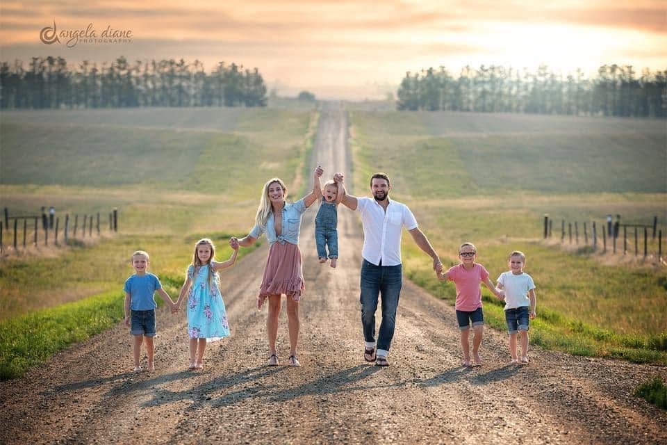 Drew Zahn with his wife and five kids on a gravel road outside Bismarck at sunset